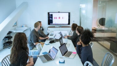 A group of colleagues benefiting from research democratization by sharing customer insights.