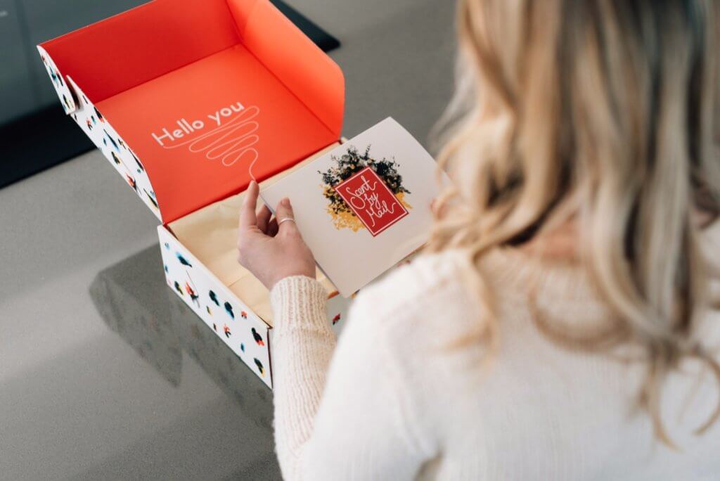 Girl unboxing a package with custom packaging that offers a unique brand experience