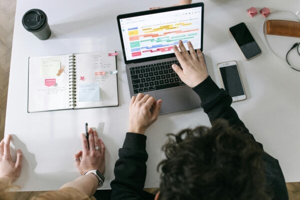 two people viewing a SaaS collaboration feature on a laptop.