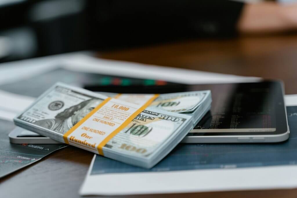 Bundles of money on top of mobile devices symbolize a successful monetization strategy.